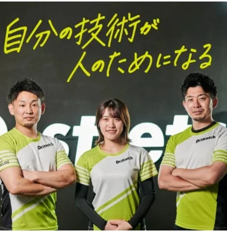 「Destretch」のロゴ入りウェアを着た男女3人のスタッフ