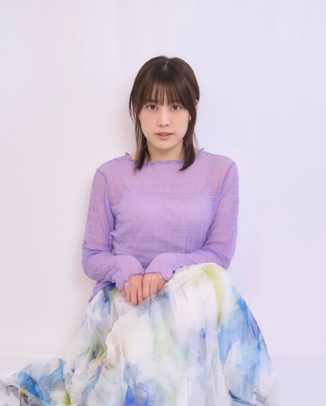 紫色のシアーシャツと花柄スカートを着用した福田沙紀監督のポートレート