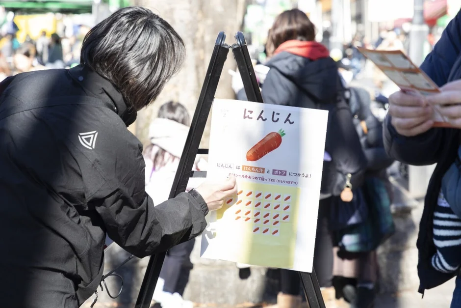 ニンジンに関する教育的な掲示板にシールを貼っている様子