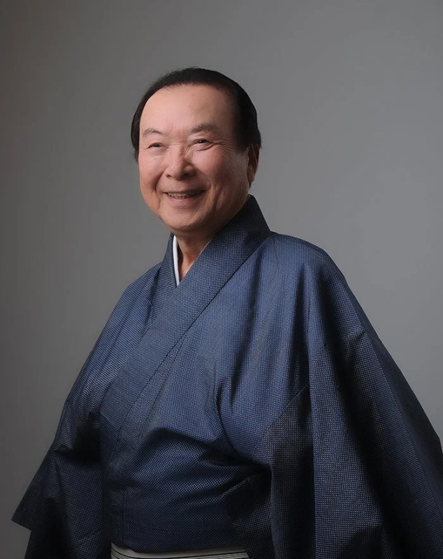 紺色の着物を着た笑顔の江河愛司さん