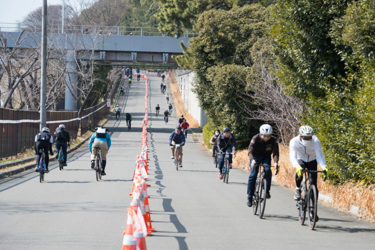 多くの人が自転車で坂道を上るサイクリングイベント