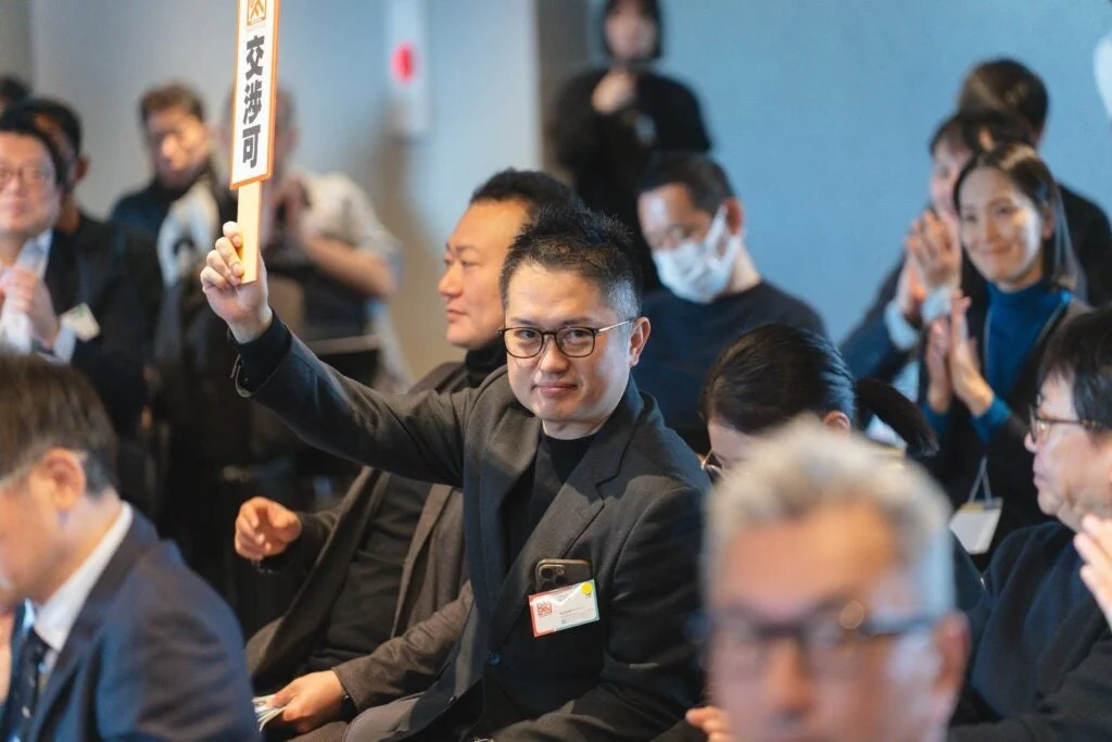 会議で交渉可のボードを掲げる男性