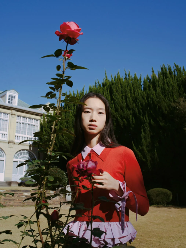 赤い服を着た女性がバラを手にしているポートレート