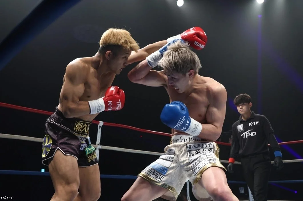 キックボクシングの試合中に、二人の男性ファイターが激しくパンチを交わしている