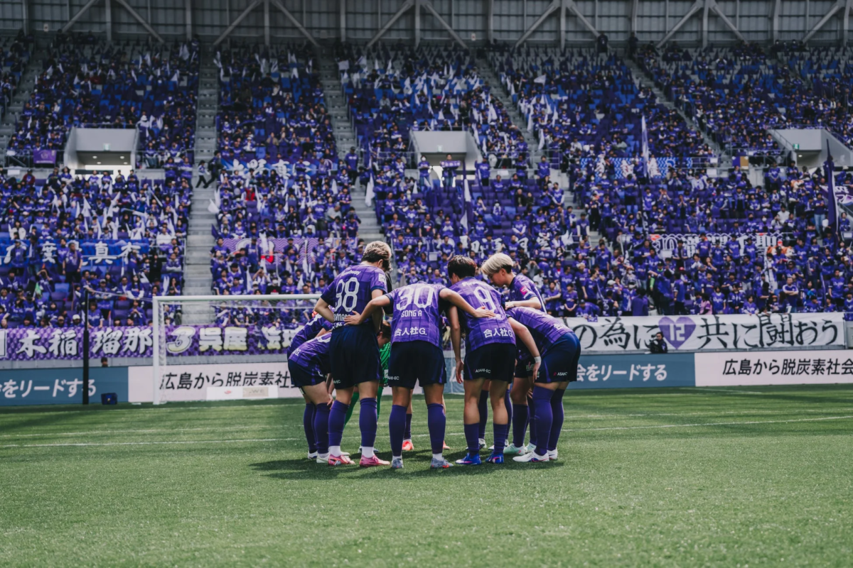 円陣を組んで結束を固める女子サッカー選手たち