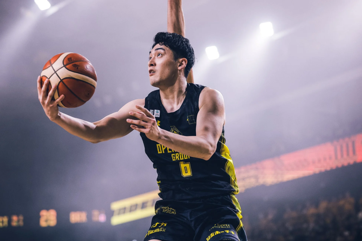 黒と黄色のユニフォームを着たバスケットボール選手が、試合中にボールを保持している瞬間