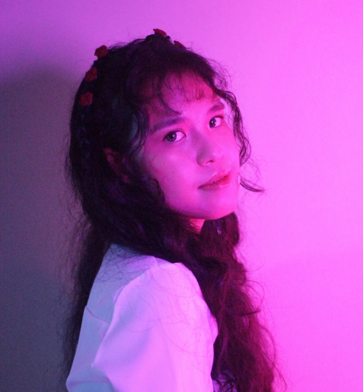 ピンクと紫のネオンライトに照らされた若い女性のポートレート