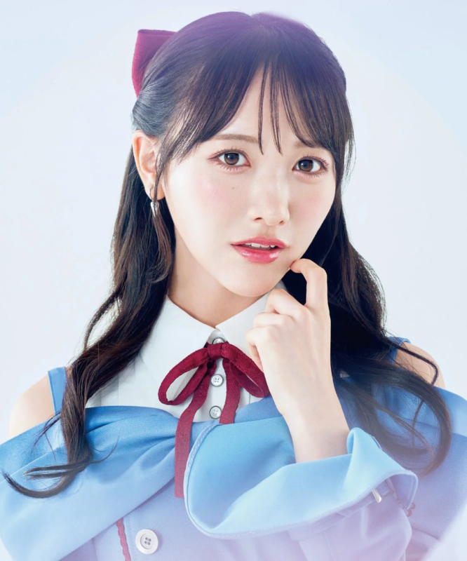 白い背景の前で青いオフショルダーの服を着た石田千穂さん
