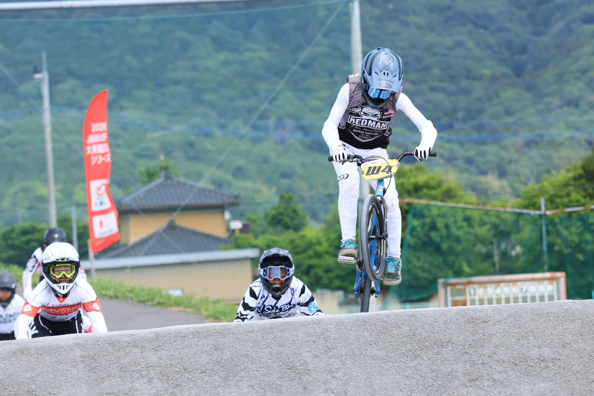 BMXレースでジャンプする少年ライダー