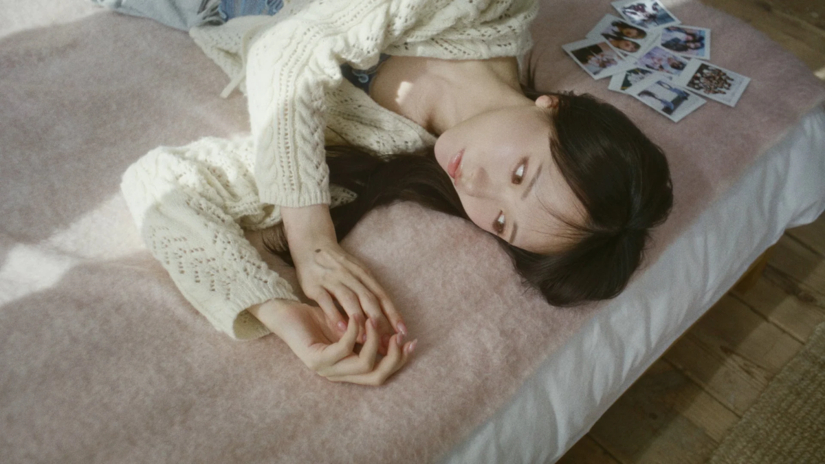 ポラロイド写真が散らばる中でリラックスした様子の石田千穂さん
