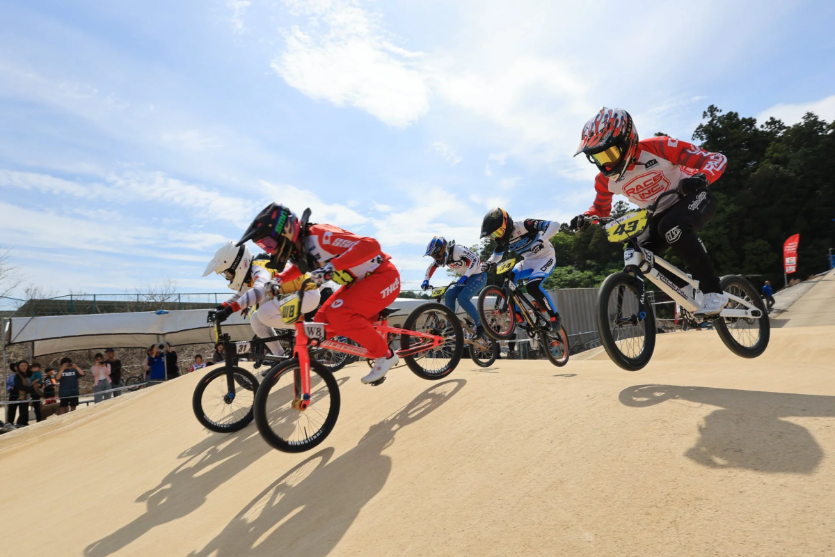 BMXレースの選手たちがジャンプ