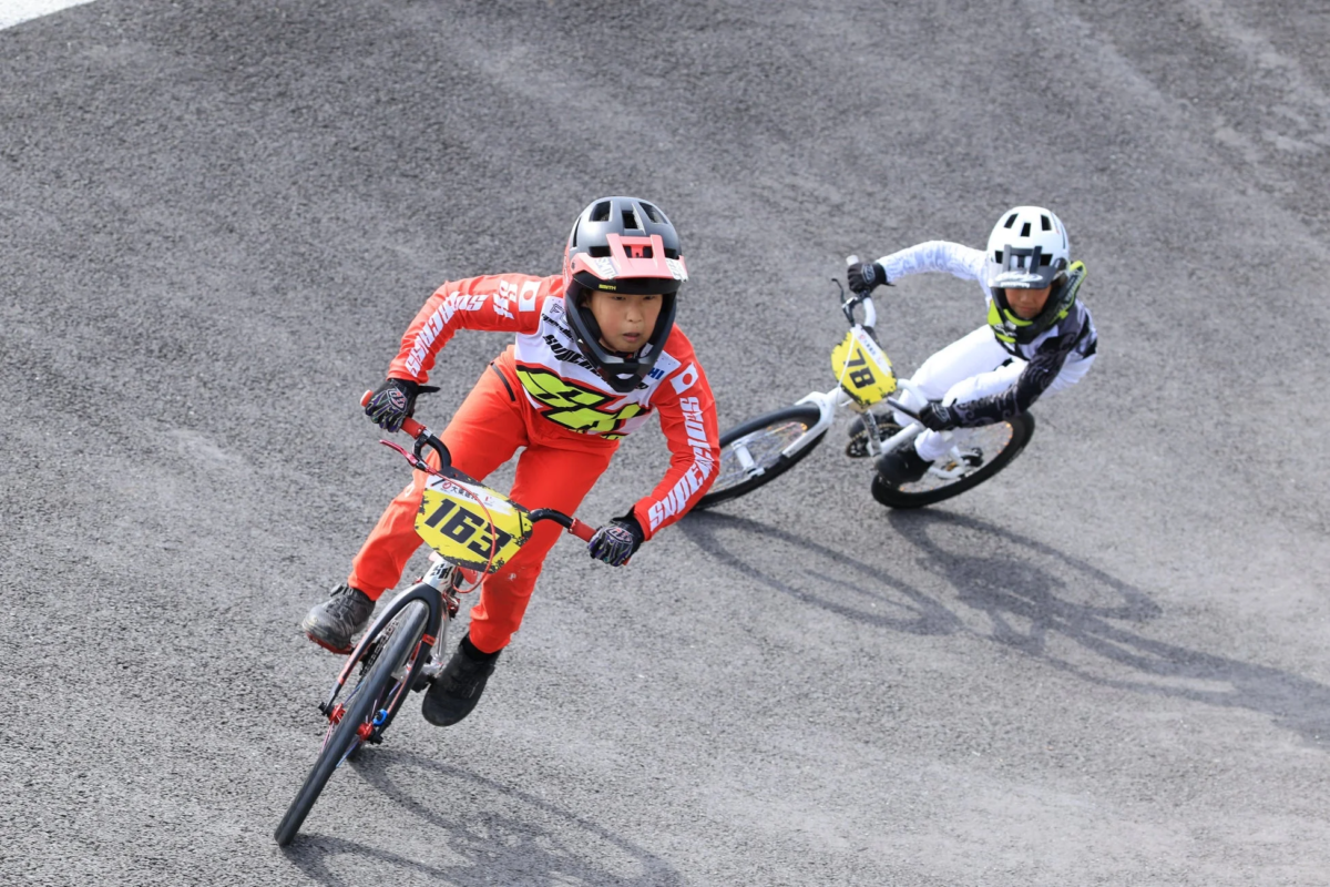 BMXレースでカーブを曲がる少年ライダーたち