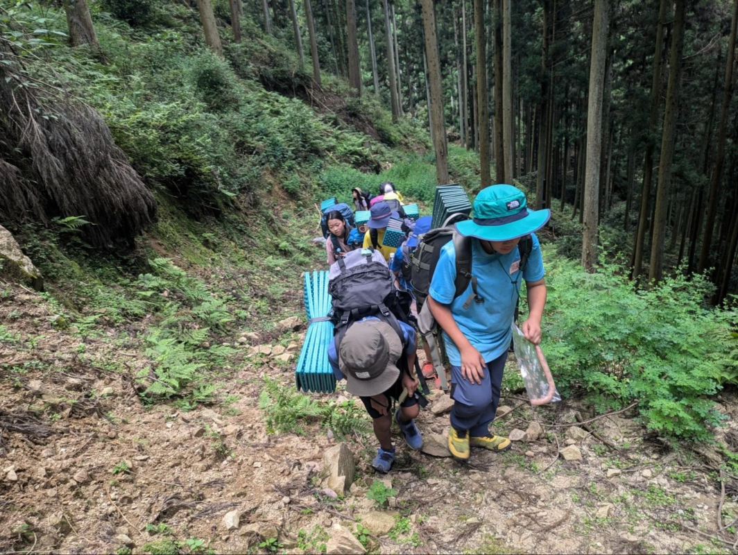 森の山道を歩く子どもたち
