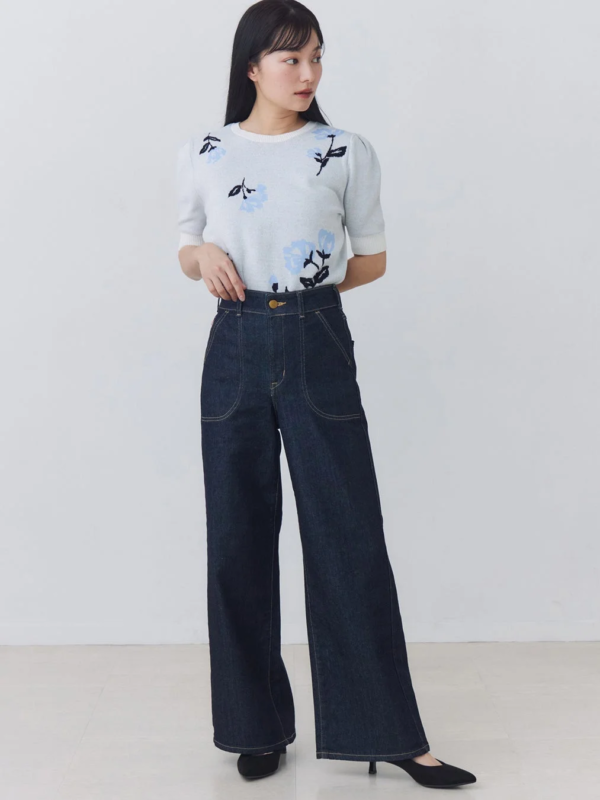 花柄ニットとワイドデニムを着用した女性