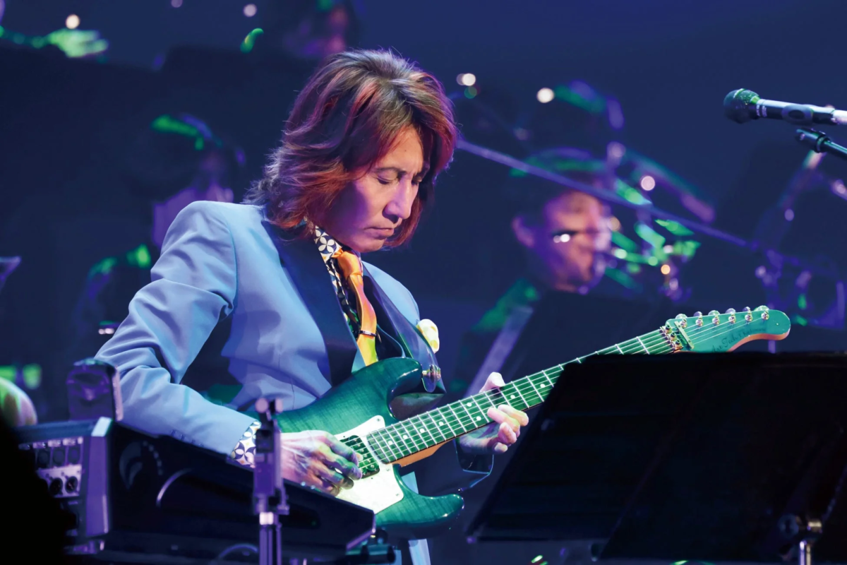 ステージでエレキギターを演奏するギタリストの姿