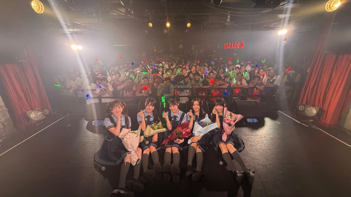 花束を持って観客と集合写真を撮るメンバー