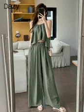 カーキ色のキャミソールとワイドパンツのセットアップを着用した女性