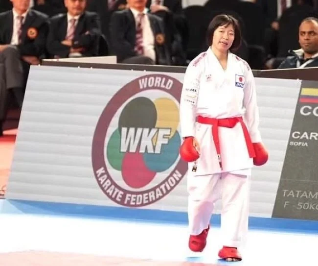 WKFのロゴが見える競技会場に立つ日本人女性空手選手